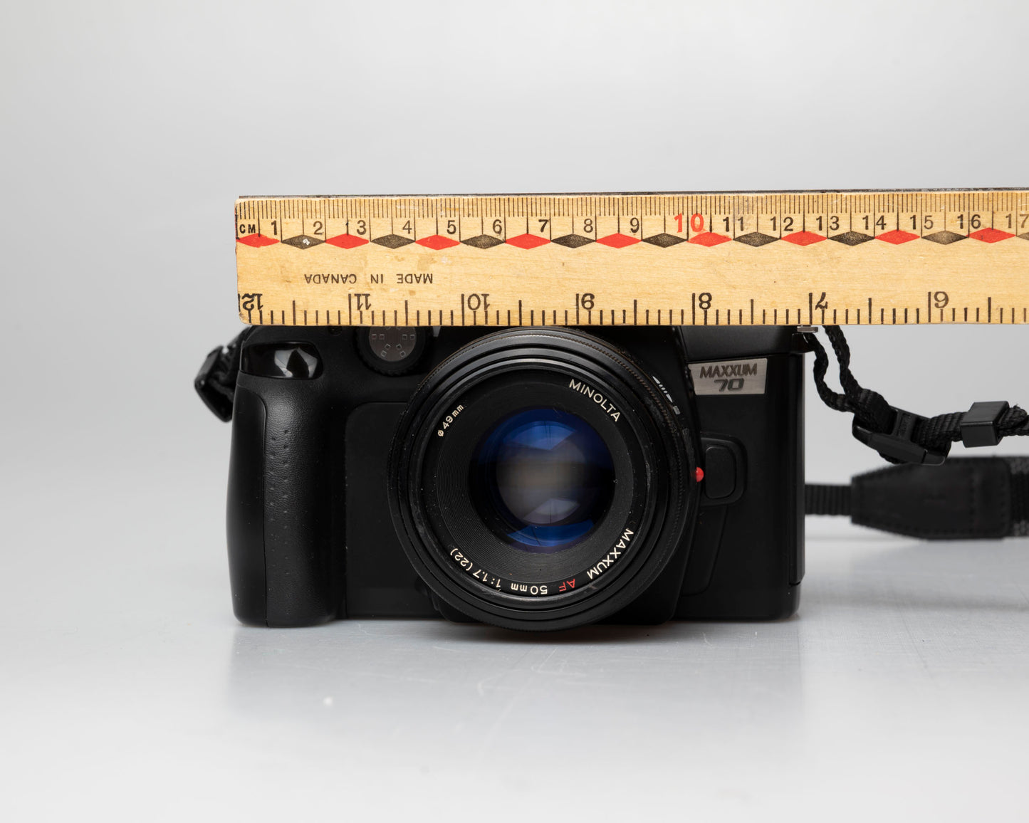 Minolta Maxxum 70 35mm film camera with 50mm f1.7 lens; front view with ruler for scale