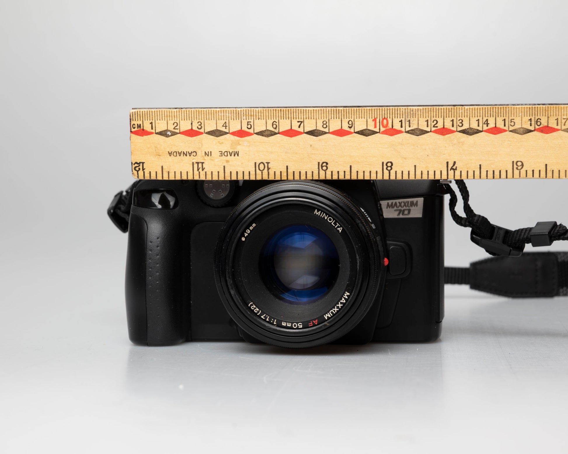 Minolta Maxxum 70 35mm film camera with 50mm f1.7 lens; front view with ruler for scale