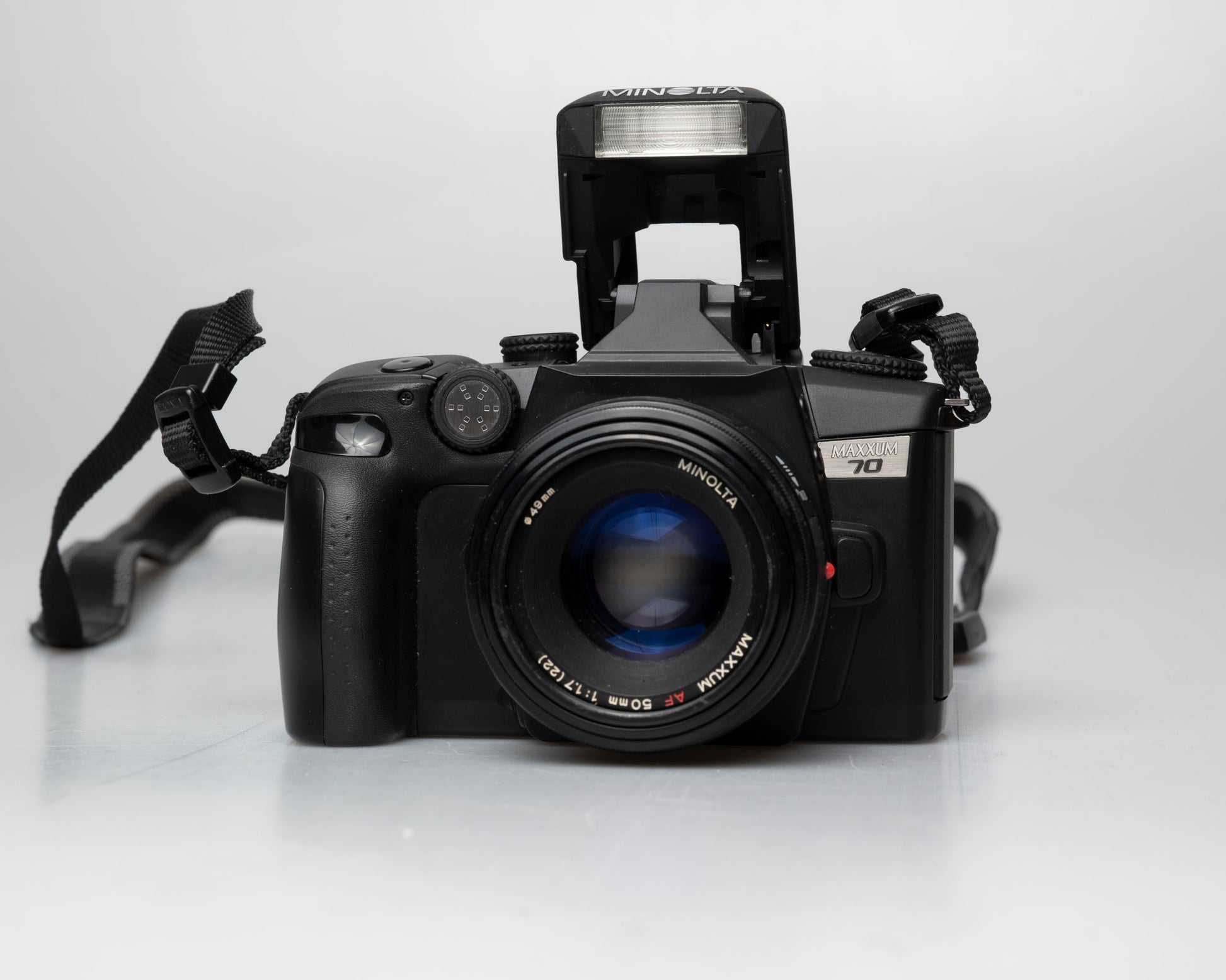 Minolta Maxxum 70 35mm film camera with 50mm f1.7 lens; front view with pop-up flash showing
