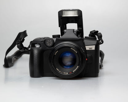 Minolta Maxxum 70 35mm film camera with 50mm f1.7 lens; front view with pop-up flash showing