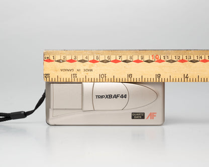 Olympus Trip XB AF44 compact 35mm film point-and-shoot camera; front view lens cover closed with ruler for scale