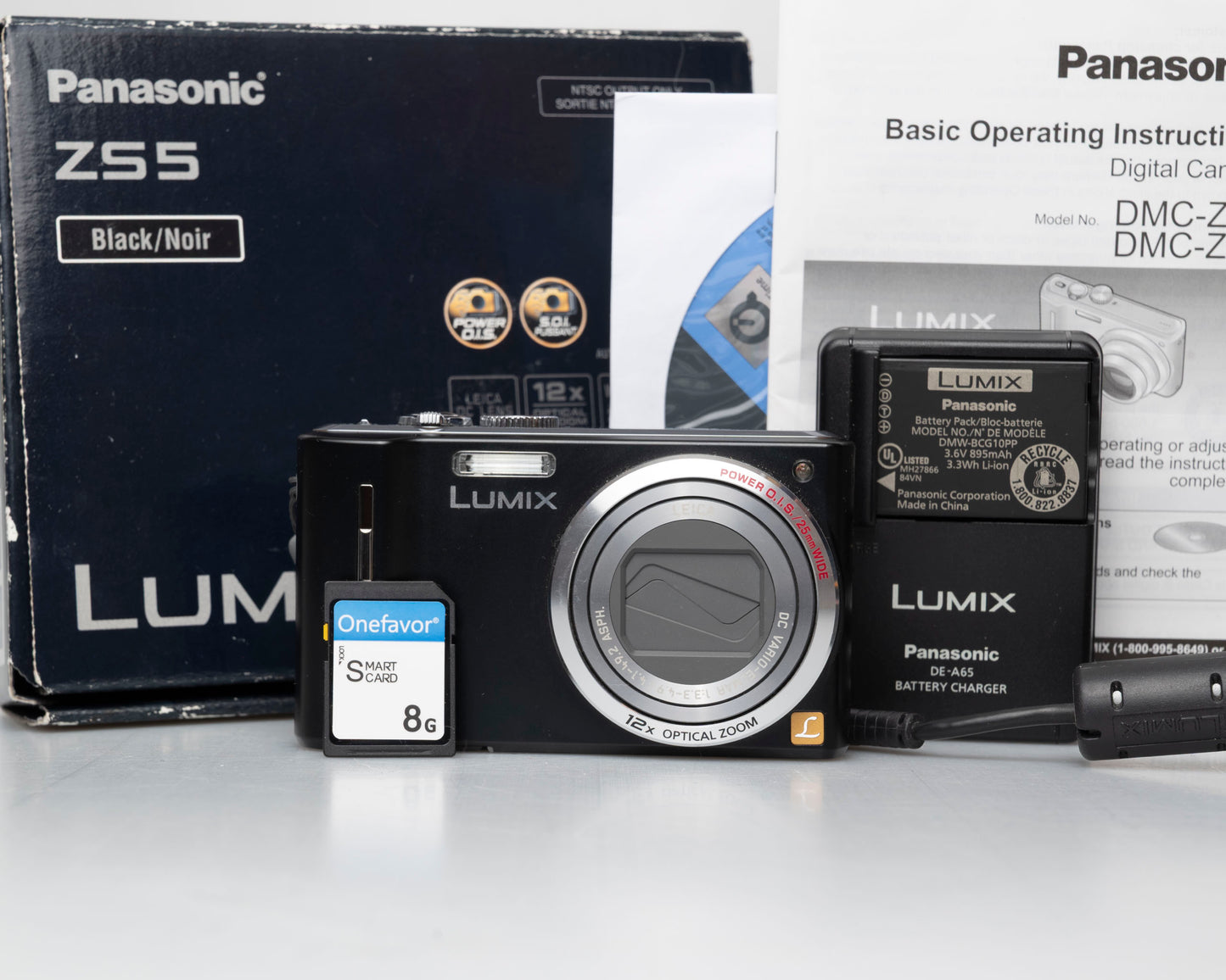 Panasonic Lumix DMC-ZS5 camera with packaging, battery, and memory card