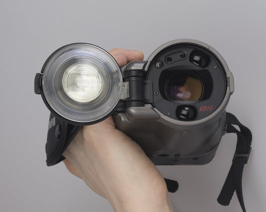 Canon Photura 35mm film camera from 1990 with a very unusual shape and design. shown here with lens cap/flash open.