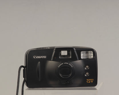 The Canon Snappy QT is a 35mm film point-and-shoot camera featuring a 32mm lens and an unusually large and bright viewfinder.