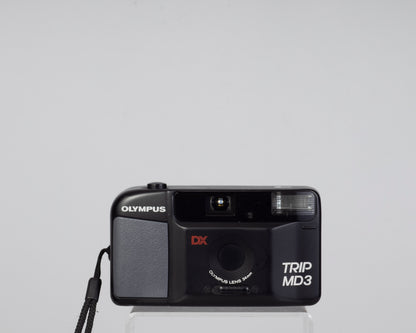 The Olympus Trip MD3 is a simple compact 35mm film camera featuring a fixed 34mm lens