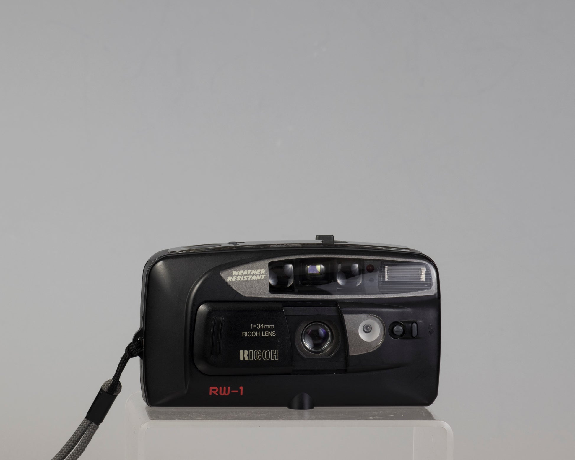 The Ricoh RW-1 Date is a 35mm film point-and-shoot camera from circa 1993. This camera features a 34mm lens and a weather resistant housing