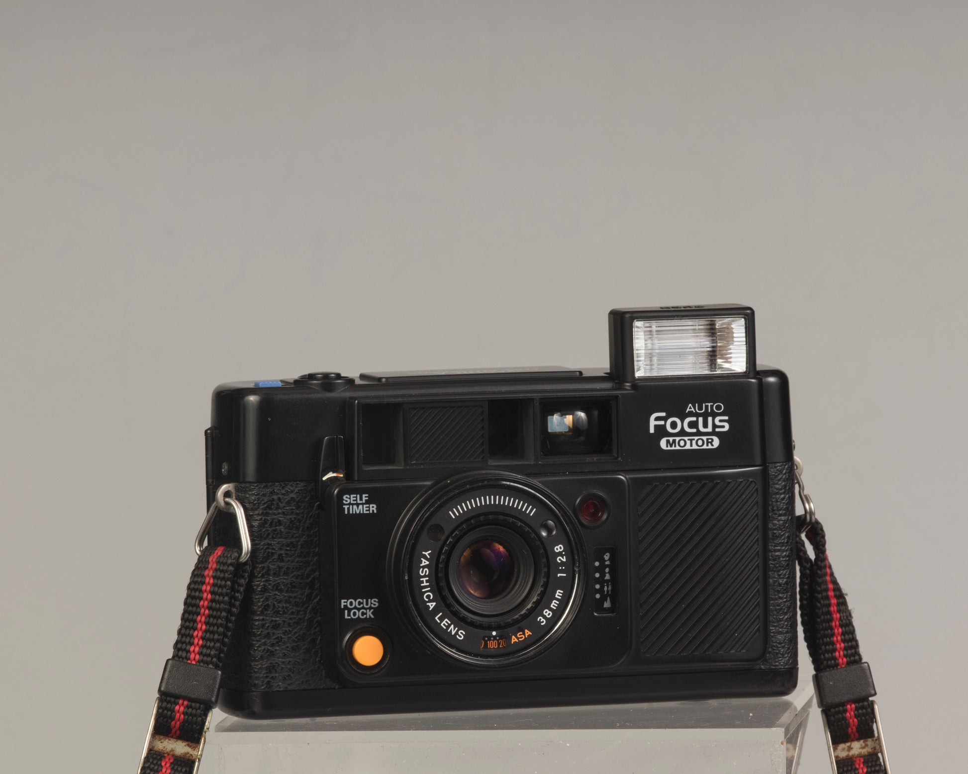 The Yashica Auto Focus Motor (shown with flash popped up) is a classic 35mm point-and-shoot film camera featuring a 38mm f2.8 lens